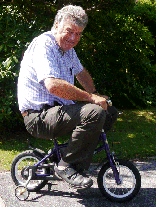 Robin Lovelock on a toddlers bike